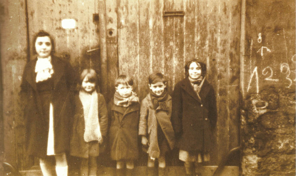 Groupe d'enfants devant une porte cochère passage des Muriers en novembre 1939. Le passage a disparu avec la ZAC des Amandiers @Parimagine - FPA