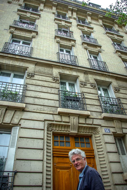Gérard Mordillat encadré dans la porte de l'immeuble du 16 rue Belgrand @J.Barret
