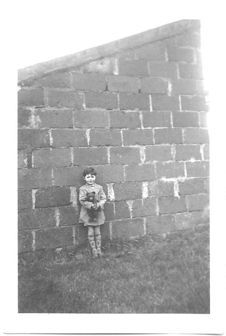 Michel Chaillou avec son ours Martin, devant le mur de la Cartonnerie dont ses grands-parents étaient gardiens
